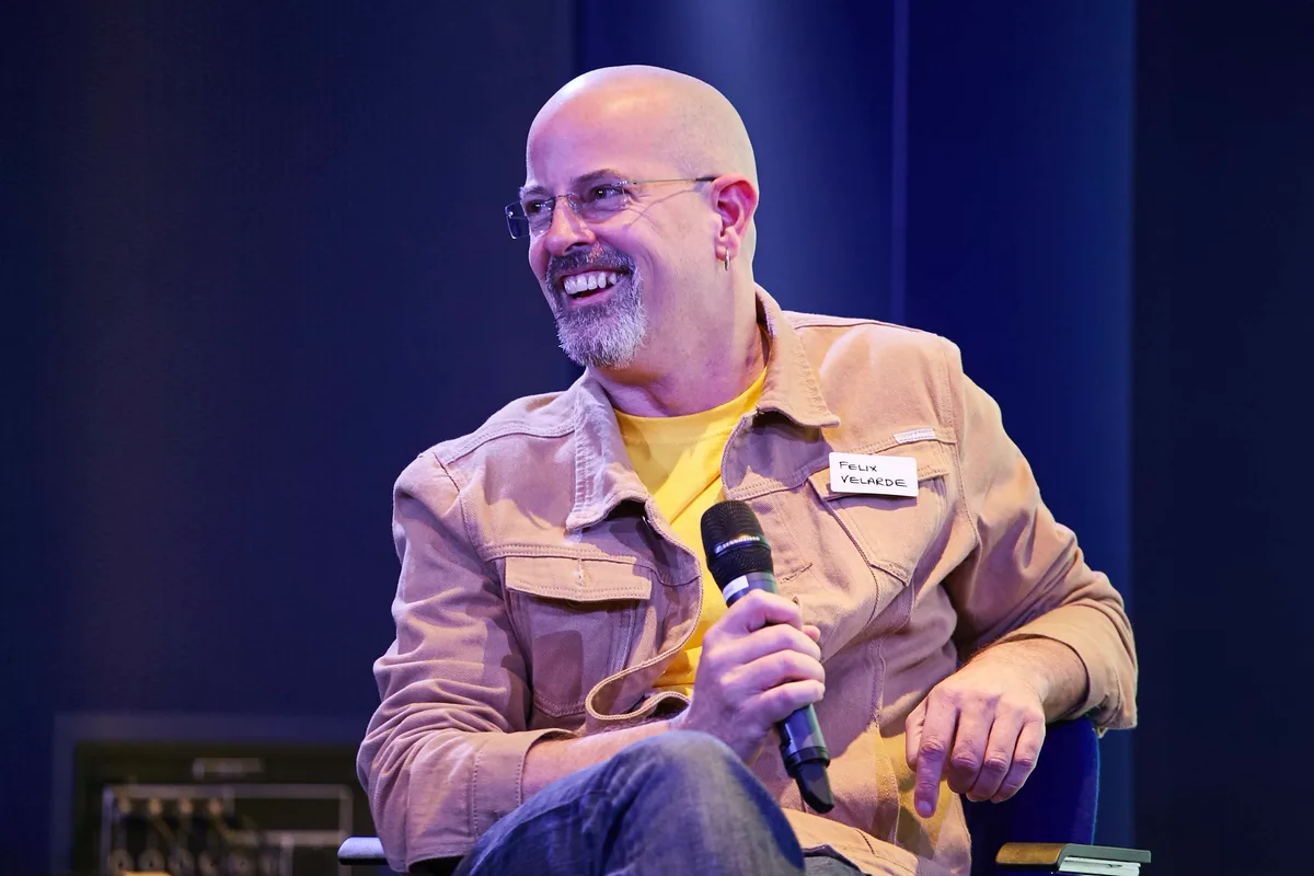 Felix Velarde on stage, holding a microphone
